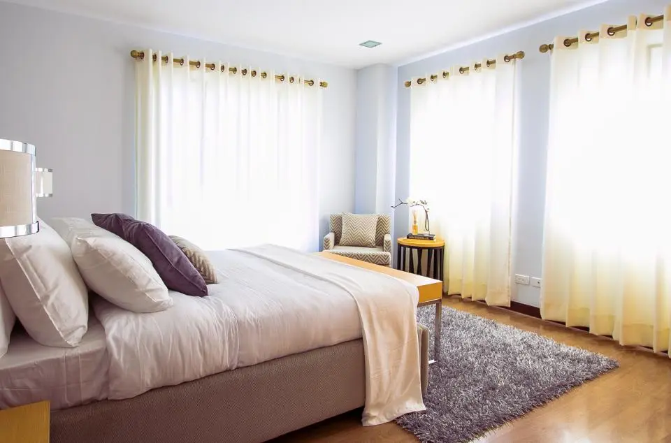 Representative photo, not the actual home: Light-filled bedroom with a double bed and sheer curtains